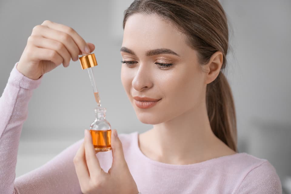 Woman applying a skincare serum with a dropper
