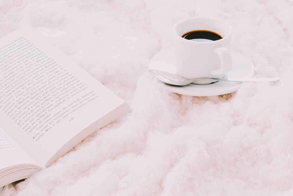 Cozy scene with a warm blanket, a cup of coffee and a book